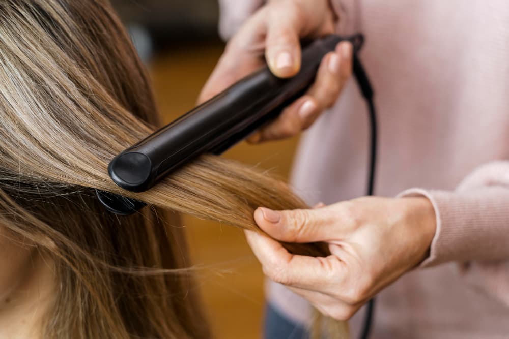 une jeune femme lisse ses cheveux